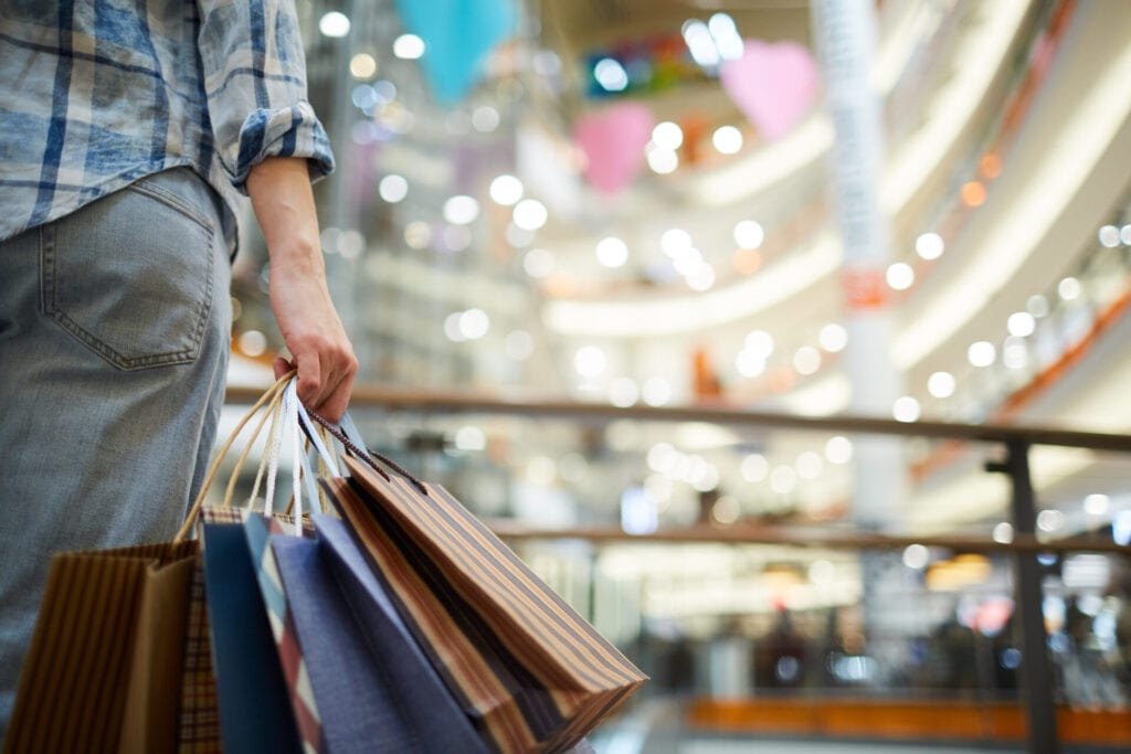 Shopper carrying bags in a mall where in-store music sets the mood