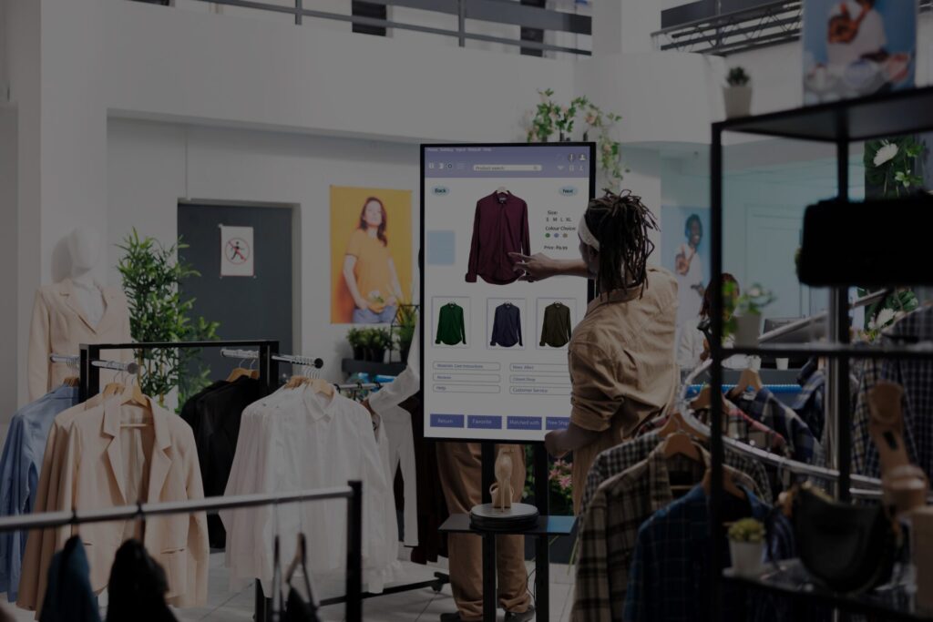 Shopper browsing clothing on a touch screen digital signage kiosk in a retail store