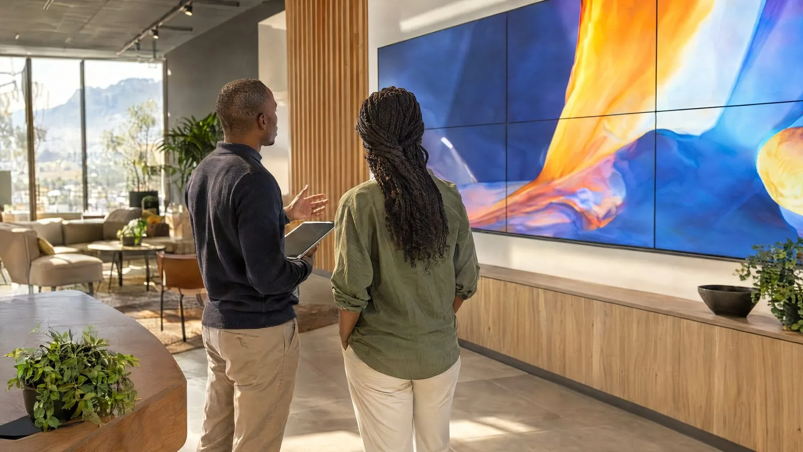 Two people discussing an LED video wall solution in a showroom